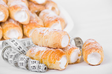 Image showing concept of slimming, cakes with measuring tape
