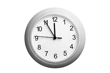 Image showing A single simple clock showing the time five to twelve