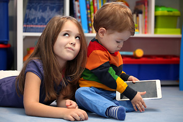 Image showing Disappointing girl with her little brother using a tablet comput