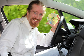 Image showing driver with CD, playing music in the car