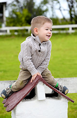 Image showing 2 years old baby boy sitting on the little rooftop