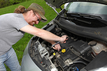 Image showing mechanic repairs a car on the road
