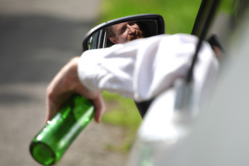 Image showing Drunk man in car with a bottle alcohol