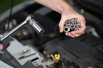 Image showing Auto mechanic with chrome plated wrench in closeup