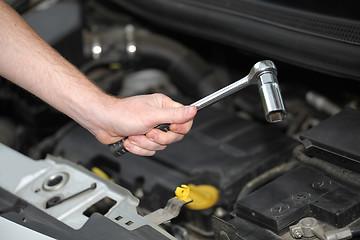 Image showing Auto mechanic with chrome plated wrench in closeup