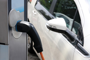 Image showing Electric car being charged at the station, close up of the power