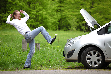 Image showing Driver furious a broken car by the road  