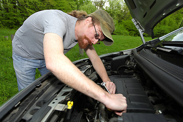 Image showing mechanic repairs a car on the road