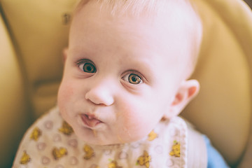 Image showing Happy Curious Young Baby Boy Eating Porridge