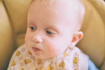 Image showing Happy Curious Young Baby Boy Eating Porridge