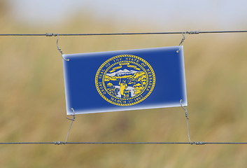 Image showing Border fence - Old plastic sign with a flag