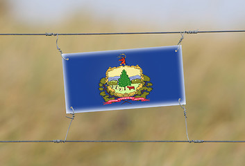 Image showing Border fence - Old plastic sign with a flag