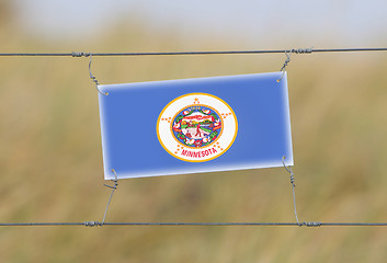 Image showing Border fence - Old plastic sign with a flag