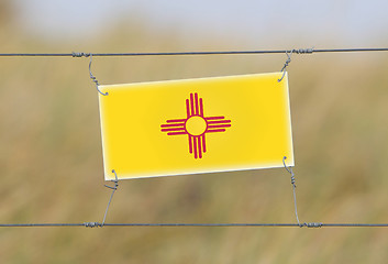 Image showing Border fence - Old plastic sign with a flag