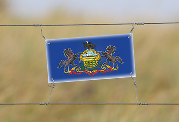 Image showing Border fence - Old plastic sign with a flag