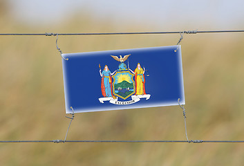 Image showing Border fence - Old plastic sign with a flag