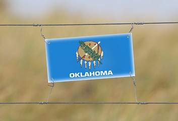 Image showing Border fence - Old plastic sign with a flag