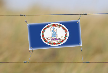 Image showing Border fence - Old plastic sign with a flag