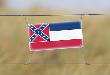 Image showing Border fence - Old plastic sign with a flag