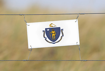 Image showing Border fence - Old plastic sign with a flag