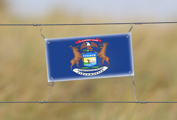 Image showing Border fence - Old plastic sign with a flag