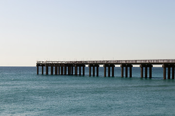 Image showing Ocean fishing pier stretchs over calm seas