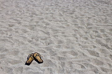 Image showing Flip flop sandals on the sandy beach