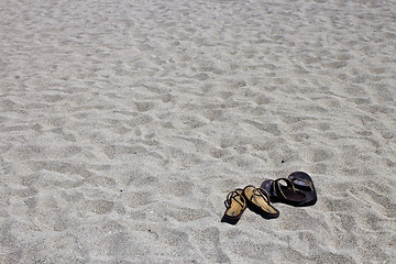 Image showing His and hers flip flop sandals on the sandy beach