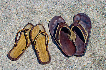 Image showing His and hers flip flop sandals on the sandy beach