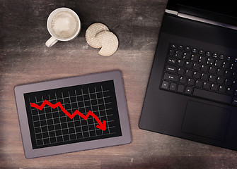 Image showing Tablet touch computer gadget on wooden table, graph negative