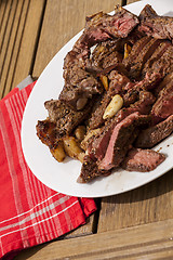 Image showing Plate of Grilled Steak and Garlic with Red Napkin