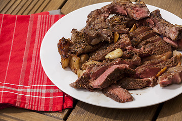 Image showing Plate of Grilled Steak and Garlic with Red Napkin