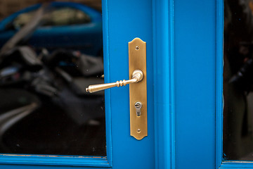 Image showing Brass door handle on a colorful blue door