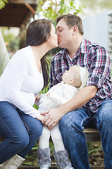 Image showing Happy Pregnant Couple Kisses as Baby Girl Watches