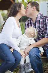 Image showing Happy Pregnant Couple Kisses as Baby Girl Watches