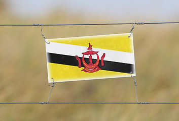 Image showing Border fence - Old plastic sign with a flag