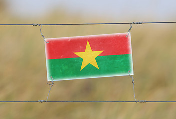 Image showing Border fence - Old plastic sign with a flag