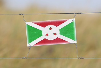 Image showing Border fence - Old plastic sign with a flag