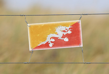 Image showing Border fence - Old plastic sign with a flag