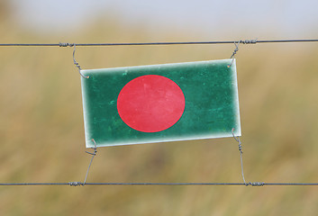 Image showing Border fence - Old plastic sign with a flag