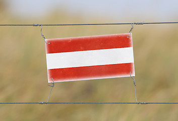 Image showing Border fence - Old plastic sign with a flag