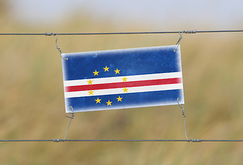 Image showing Border fence - Old plastic sign with a flag