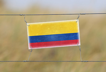 Image showing Border fence - Old plastic sign with a flag