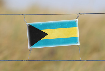 Image showing Border fence - Old plastic sign with a flag