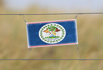 Image showing Border fence - Old plastic sign with a flag