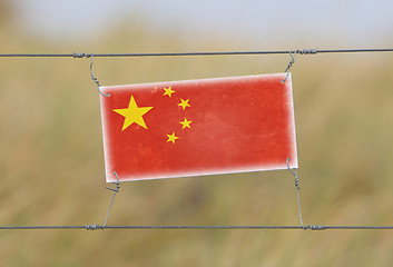 Image showing Border fence - Old plastic sign with a flag