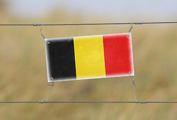 Image showing Border fence - Old plastic sign with a flag