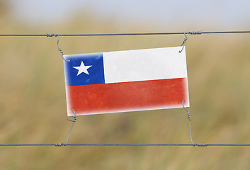 Image showing Border fence - Old plastic sign with a flag