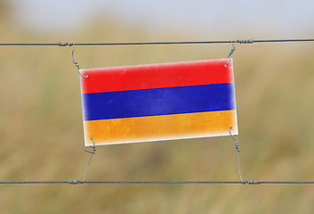 Image showing Border fence - Old plastic sign with a flag