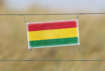 Image showing Border fence - Old plastic sign with a flag